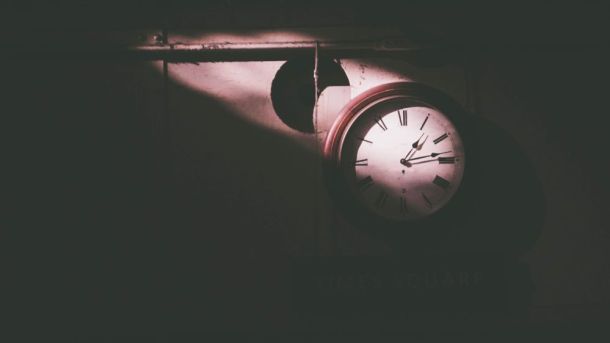Clock in a dark room with ray of sun shining on it
